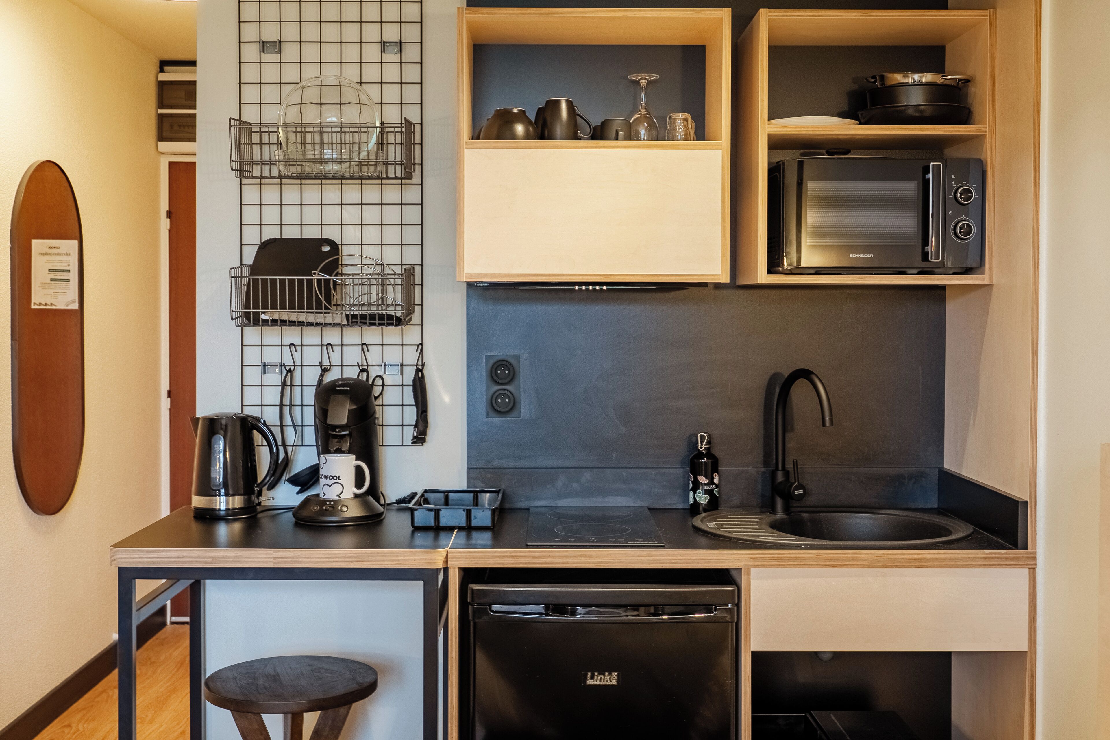 A compact kitchen with a microwave, coffee maker, and a dishwasher.