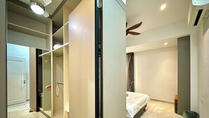 Een moderne hotelkamer met een grote spiegel, een bed, een plafondventilator en een inloopkast.