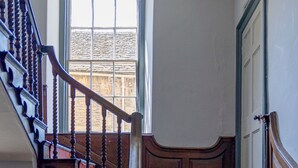A wooden staircase with red carpeted steps leading to a door. - Cozy Corsham Apartment With 2 Bedrooms (Corsham)