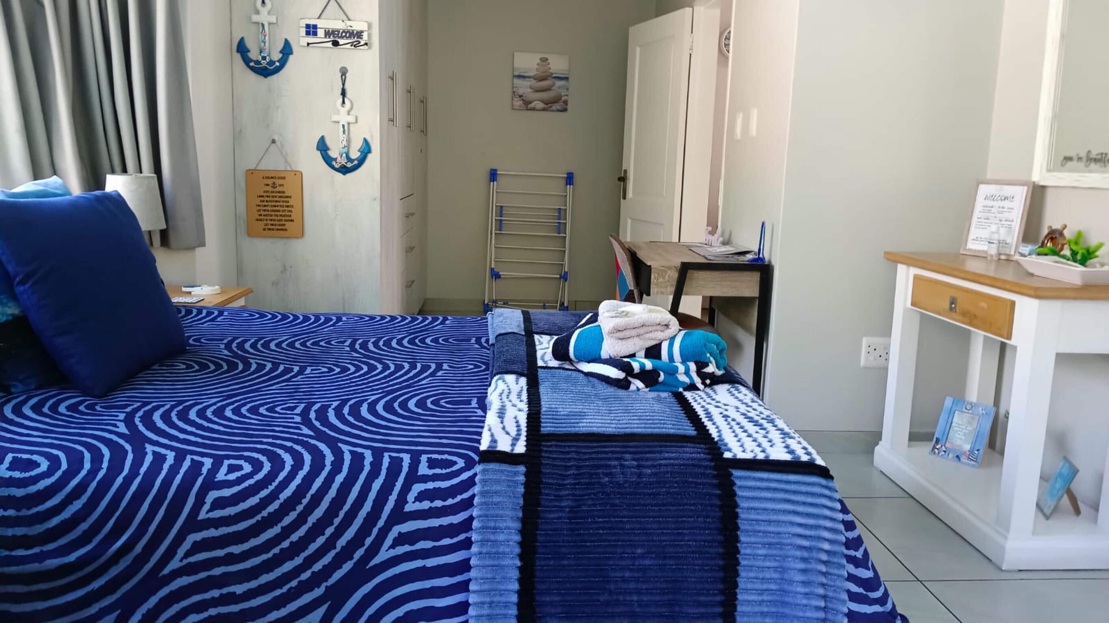 A bedroom with a bed, a desk, a wardrobe, and a 'Welcome' sign.