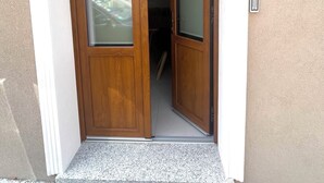 A wooden door with glass panels and a white threshold. - Domus Luxi - Teulada Design Apartment | Style and Comfort (Teulada)