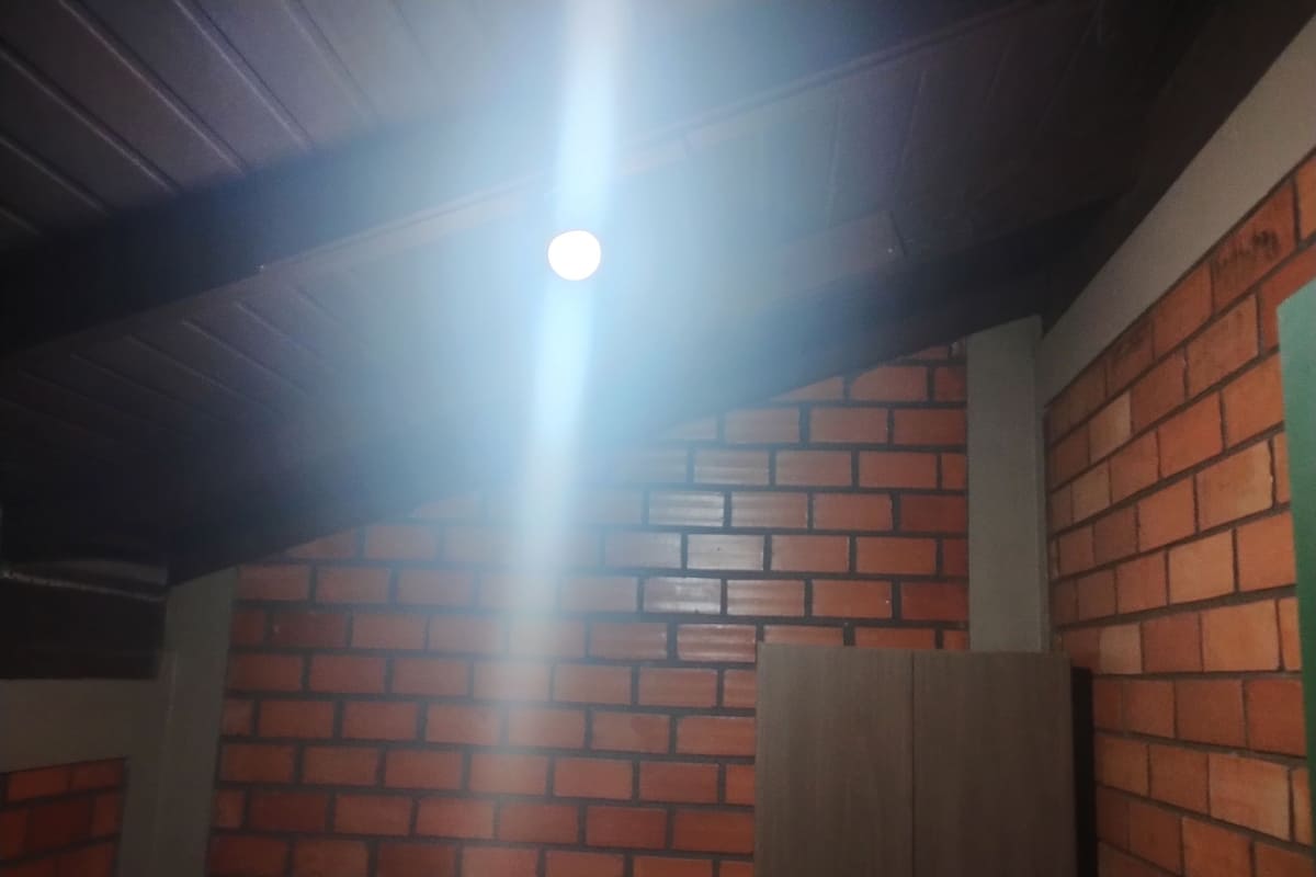 A room with a brick wall and wooden ceiling beams.