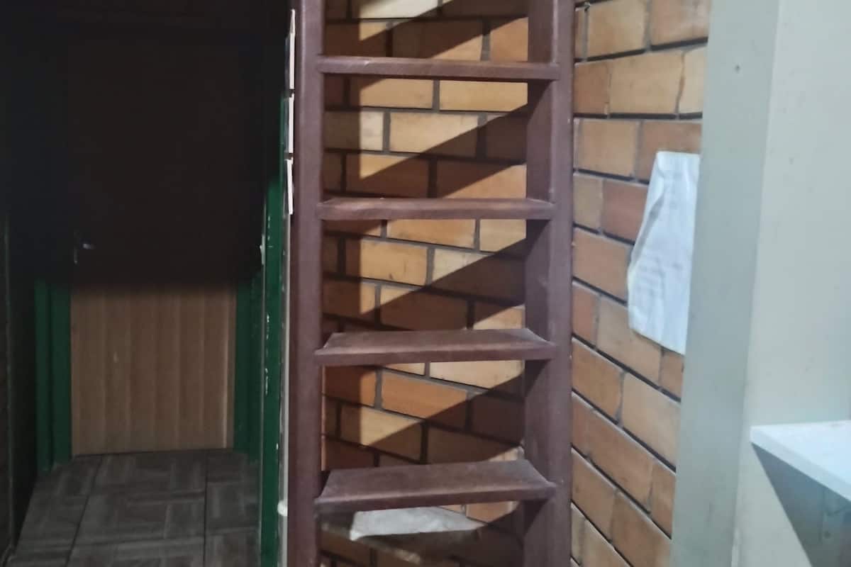 A spiral staircase with a wooden finish, leading to an upper level.