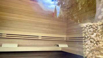 A sauna with wooden benches and a stone wall.