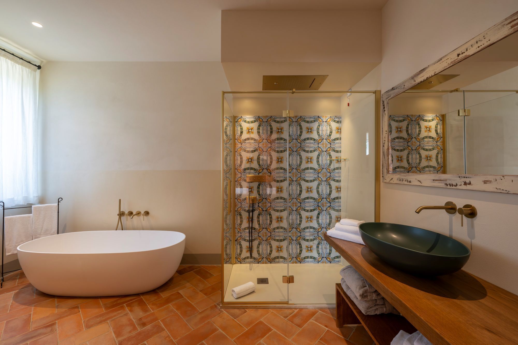 A modern bathroom with a freestanding bathtub, a glass-enclosed shower, and a large mirror.