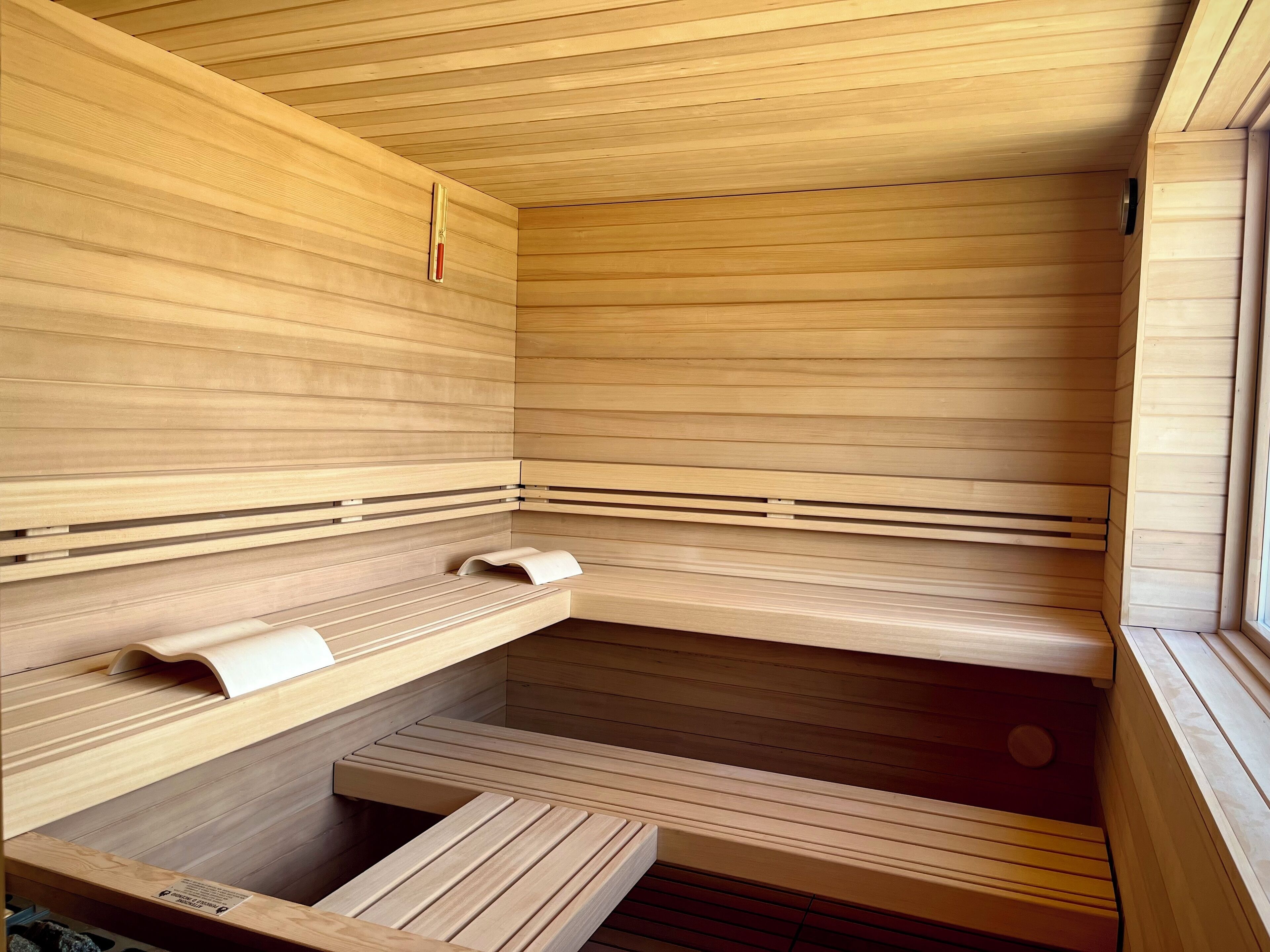 A sauna with wooden benches and a bench with a towel.