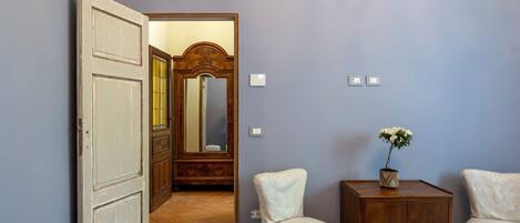 Une chambre à coucher comprenant un lit, une table de chevet, une chaise, une commode et un miroir.