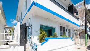 A modern building with a white facade and blue accents, featuring a number '106' on the side.