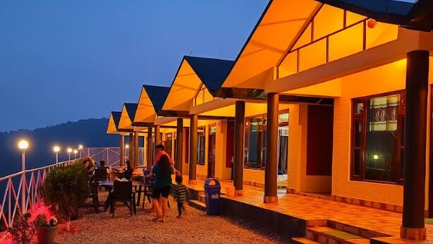 Fila de edificios modernos y bien iluminados, con suelo de grava, probablemente un hotel o resort.