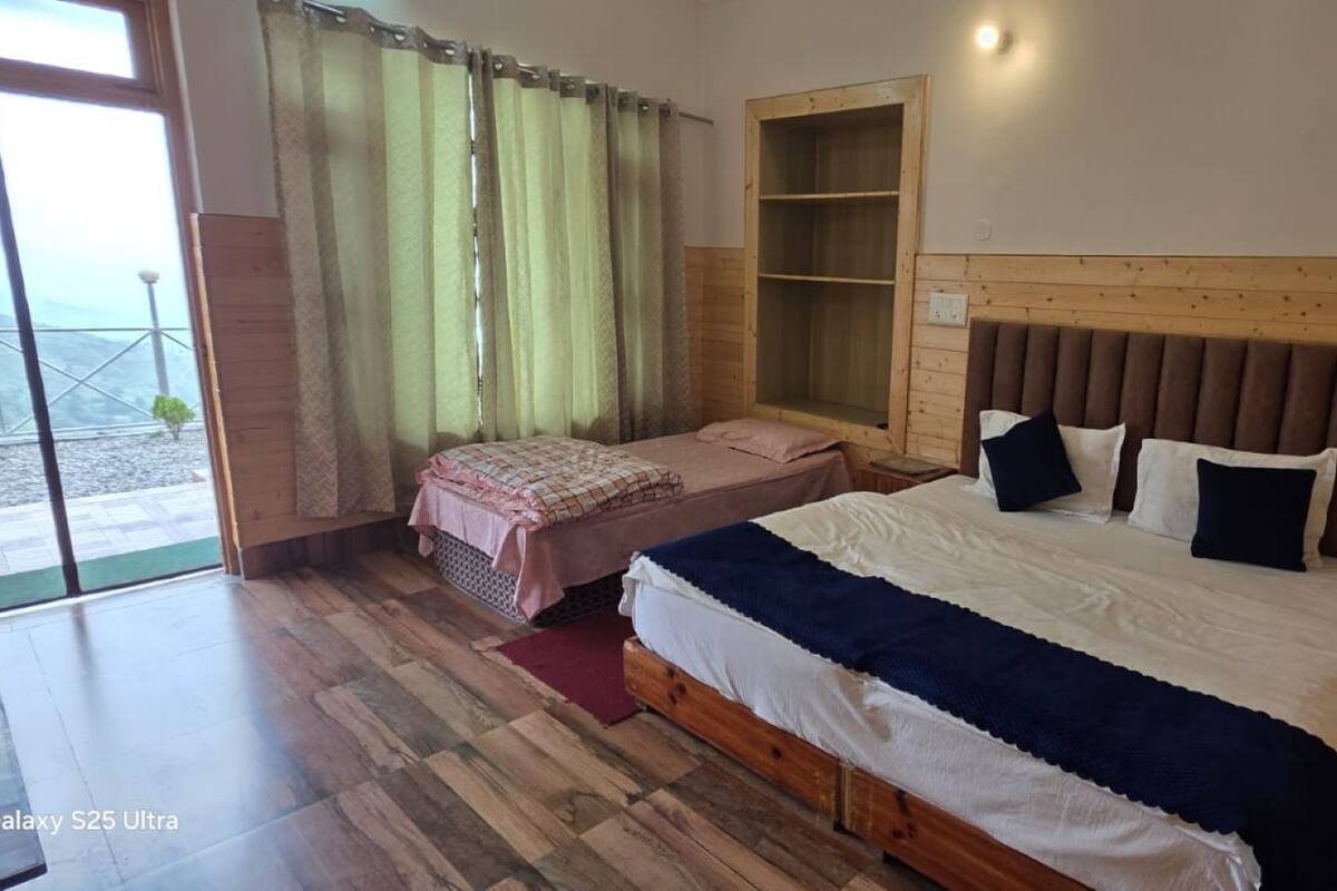 Une chambre à coucher avec un grand lit, une tête de lit en bois, une table de chevet, un banc et une fenêtre avec des rideaux.