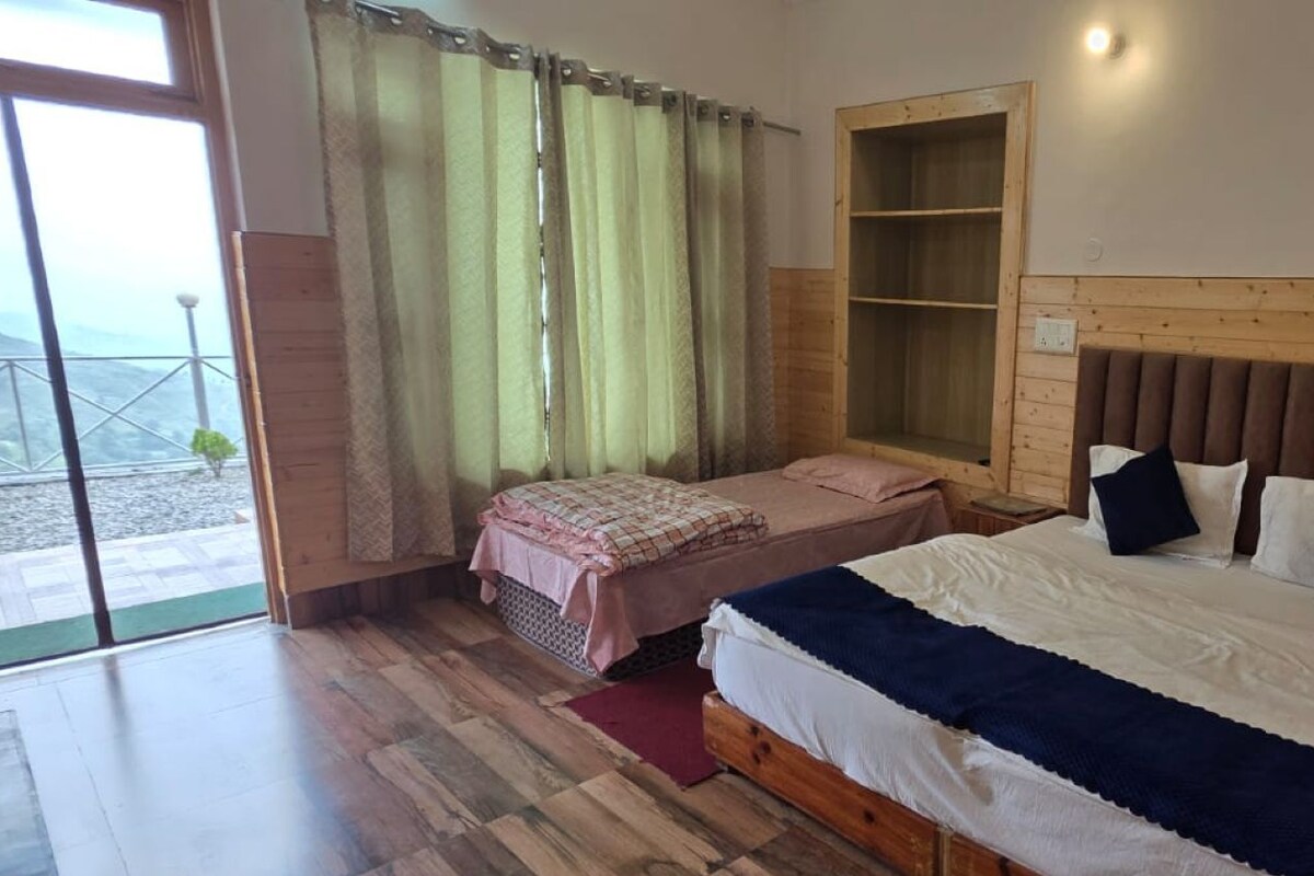 A bedroom with a large bed, a wooden headboard, a bedside table, a bench, and a window with curtains.