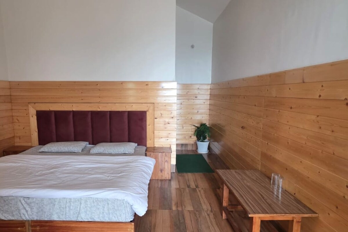 A Galaxy S25 Ultra bed in a room with wooden walls and a wooden floor.