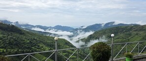 A mountainous landscape with a view of terraced fields and a guardrail with spherical lights. - Chakrata Hills Resort (Chakrata)