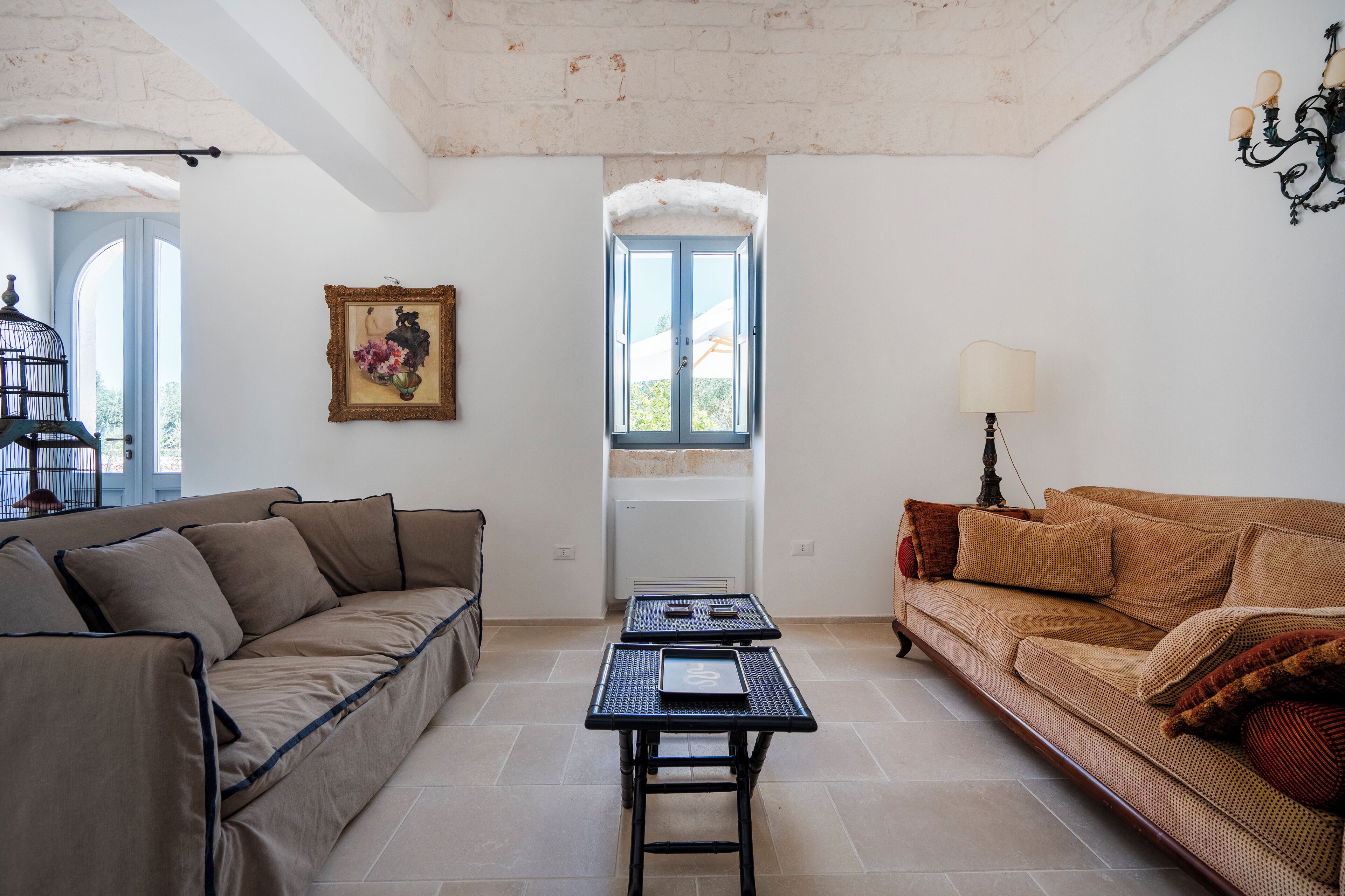 A living room with a sofa, a coffee table, and a window with a view.