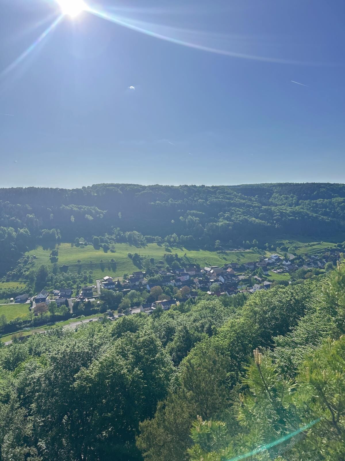 A rural landscape with a small village and surrounding greenery.