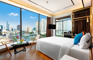 A hotel room with a city view, a bed, a TV, and a desk with a chair. - G8 Riverside Hotel & Rooftop Skybar (Ho Chi Minh City)