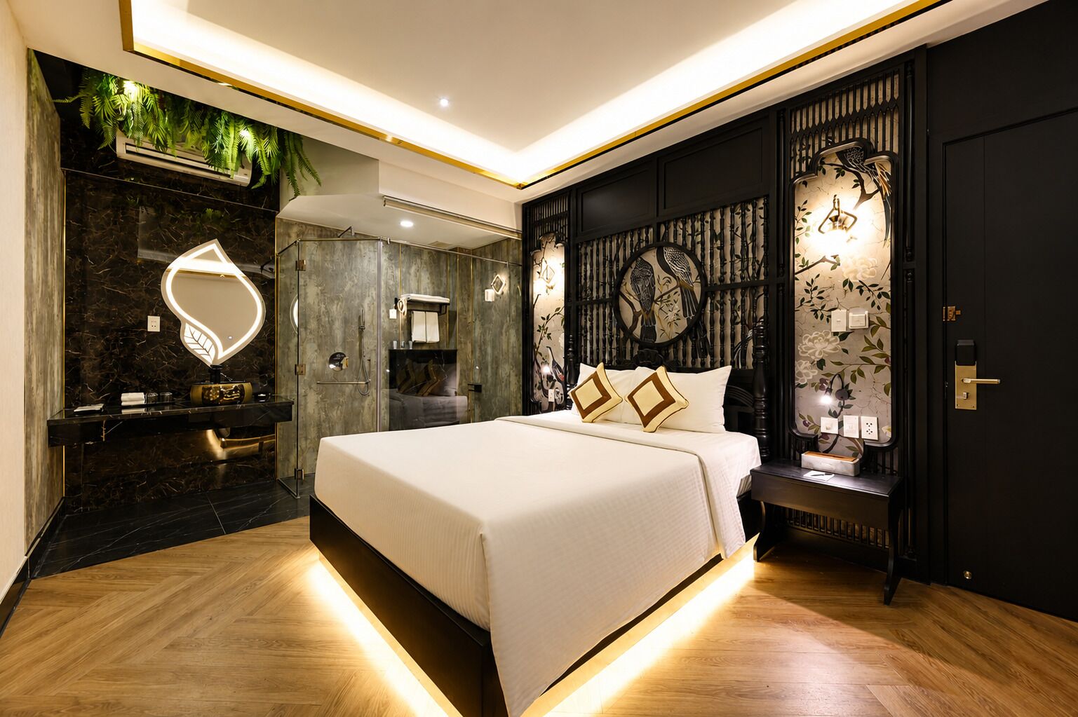 A modern bedroom with a large bed, a vanity with a mirror, and a wall-mounted toilet.