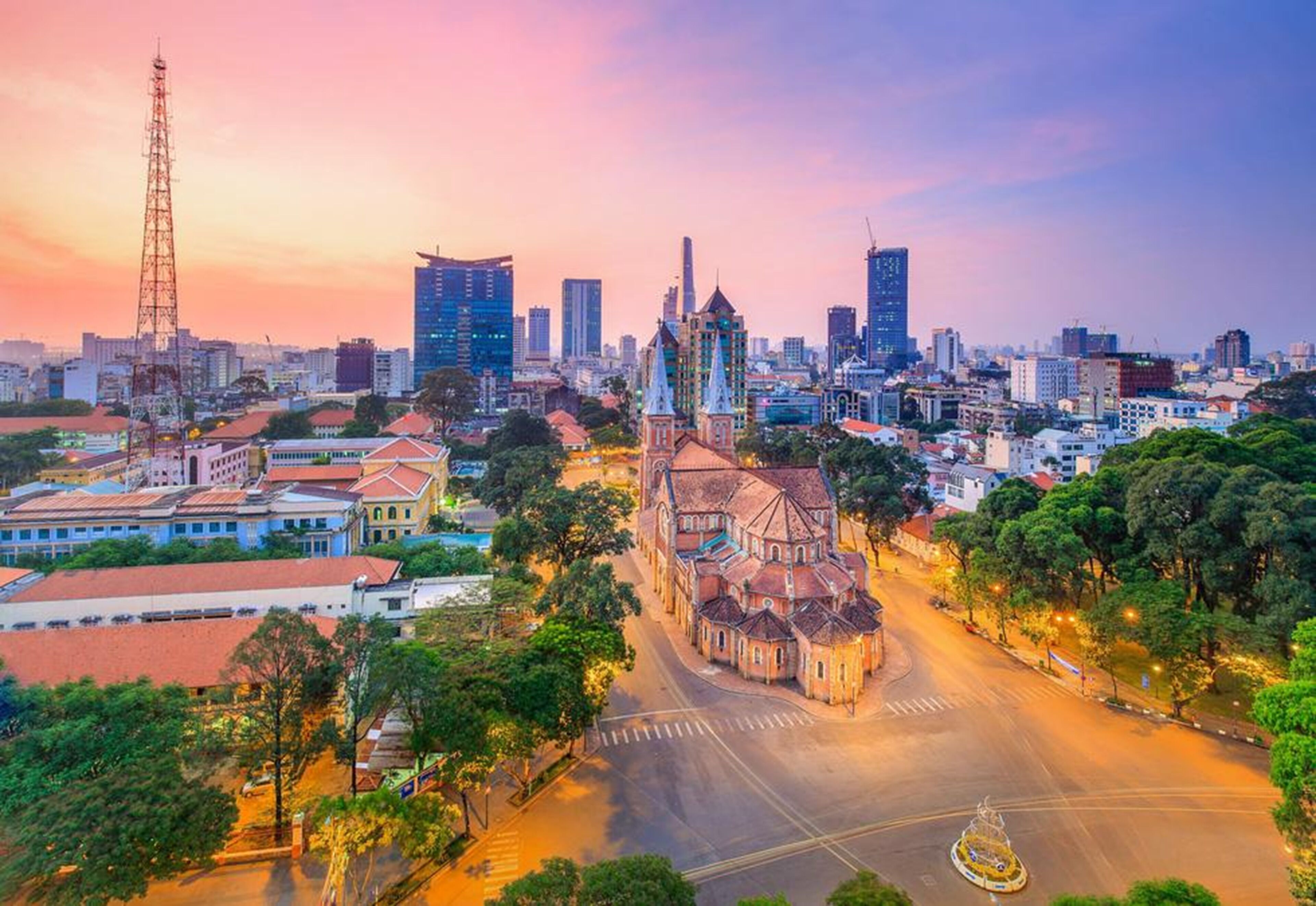 A cityscape with a prominent church, modern buildings, and a clear sky.