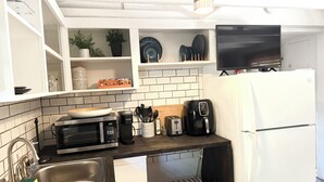 Eine Küche mit Mikrowelle, Toaster, Kaffeemaschine und Kühlschrank.