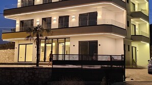 A multi-story hotel with balconies, large windows, and a stone facade.