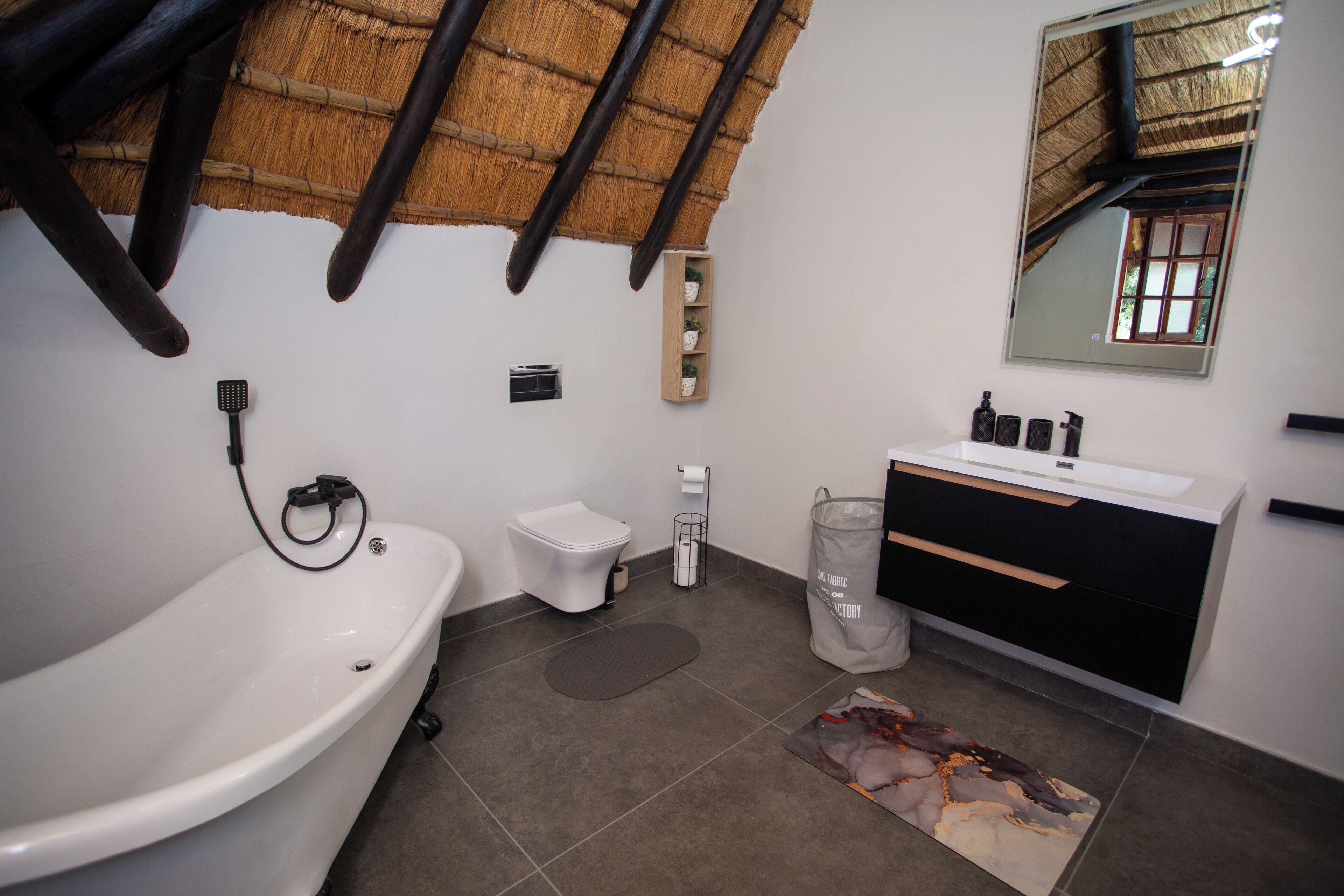 Ein modernes Badezimmer mit Badewanne, Toilette und Waschtisch.