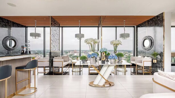 Ein moderner, offener Wohnbereich mit Essplatz, Bar und Sitzgelegenheiten.