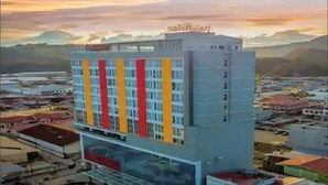 A multi-story hotel with a modern design, featuring a prominent red and yellow facade. - Hotel Horison Ultima Entrop (Jayapura)