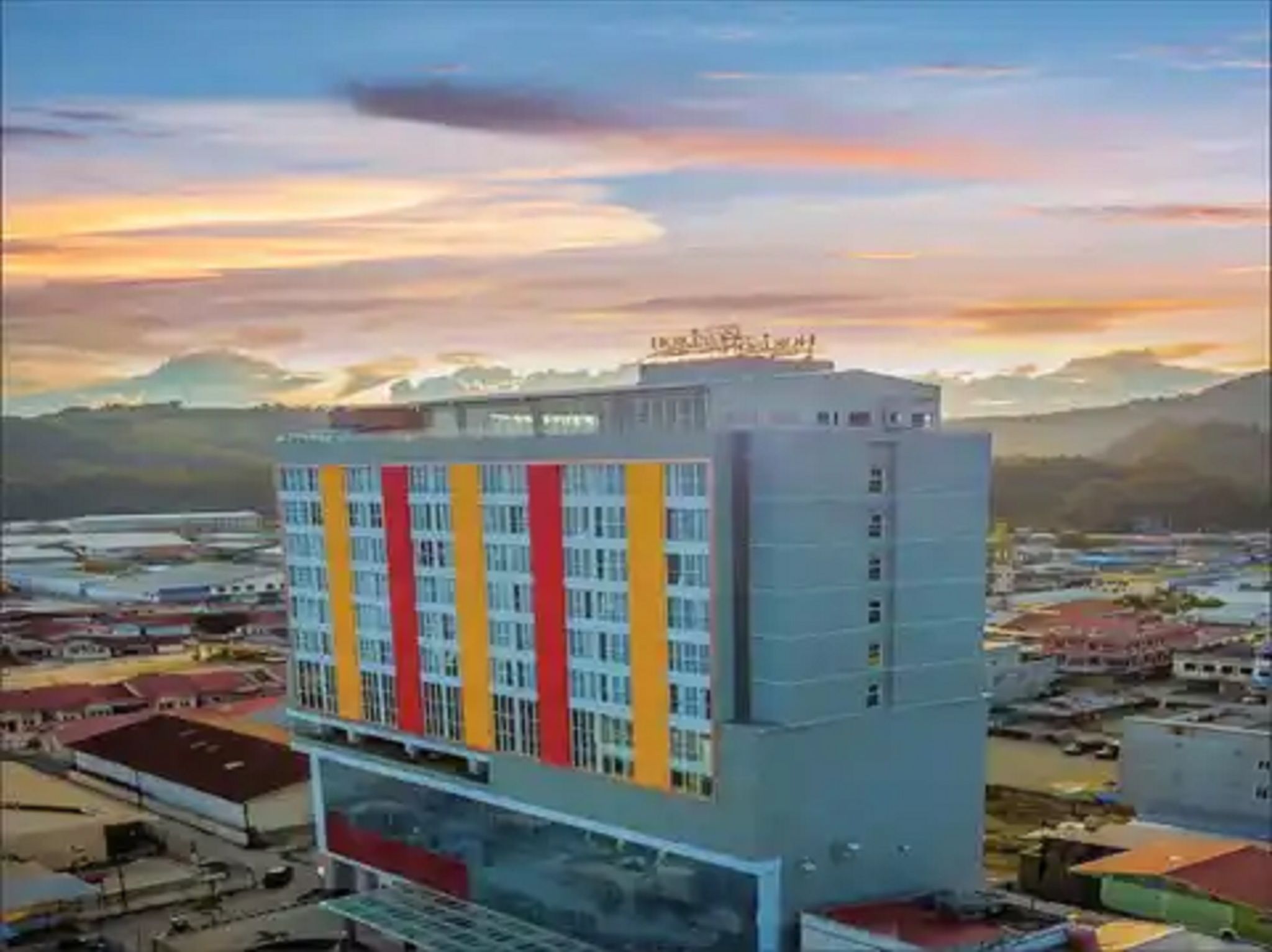 Um hotel com vários andares e design moderno, com uma fachada em vermelho e amarelo.