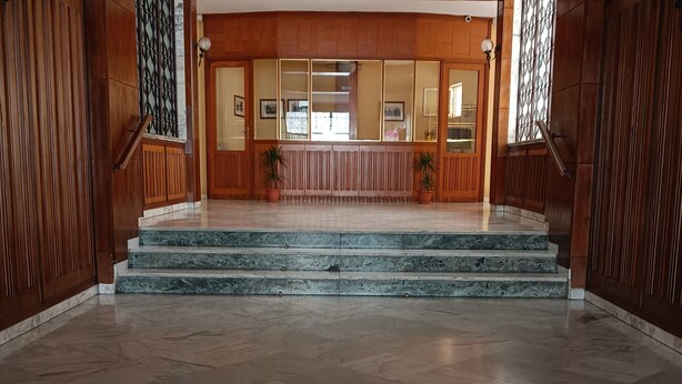 Une entrée imposante avec des marches en marbre menant à un espace d’accueil.