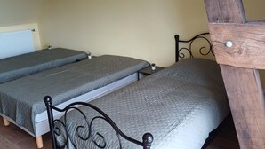 A room with three single beds, a radiator, and a small potted plant. - Logis de la Provosterie - CROCUS (Ahuille)