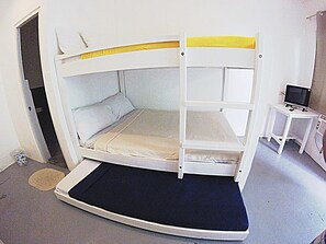 A bunk bed with a desk and a television. - Dormitels.ph - El Nido (El Nido)
