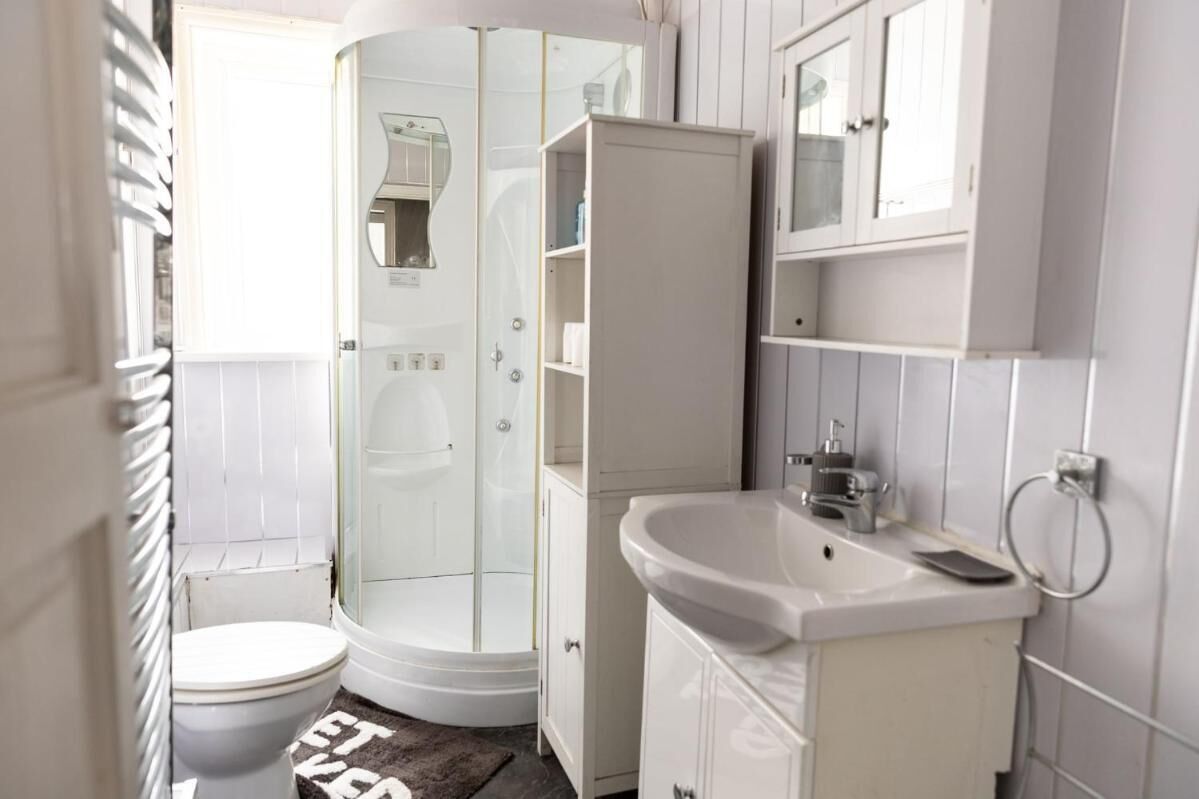 A bathroom with a toilet, a shower, and a sink.