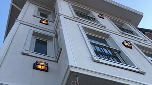 A multi-story building with a white exterior, multiple windows, and exterior lighting fixtures. - Olimarin Otel (Mudanya)