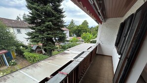 A balcony with a metal railing, a view of a tree, and a building in the background. - Cozy terraced house for up to 8 people1 minute from the trade fair (Offenburg)