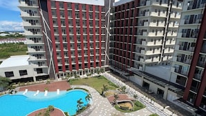 Un hôtel moderne à plusieurs étages, doté d’une cour intérieure avec une piscine et d’un jardin bien entretenu.