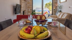 A dining table with a fruit platter, a cake, and a teapot. - The Hospitality of the 11 Brothers (kissamos)