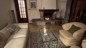 Una sala de estar con chimenea, un sofá, un sillón y una mesita de centro.