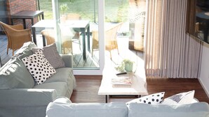 A modern living room with a grey sofa, white cushions, and a coffee table with a book and a plant. - Zum Brandenburger Tor 13 (Damme)