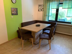 A dining area with a wooden table and brown cushioned seating. - Apartment 'Ödbach' with Shared Terrace, Private Garden and Wi-Fi (Konzell)