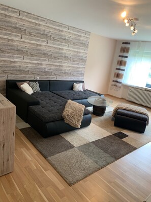 A modern living room with a sectional sofa, a coffee table, and a fireplace. - Apartment 'Ödbach' with Shared Terrace, Private Garden and Wi-Fi (Konzell)