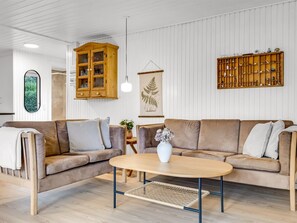 En moderne stue med en hjørnesofa, et sofabord og dekorative genstande.