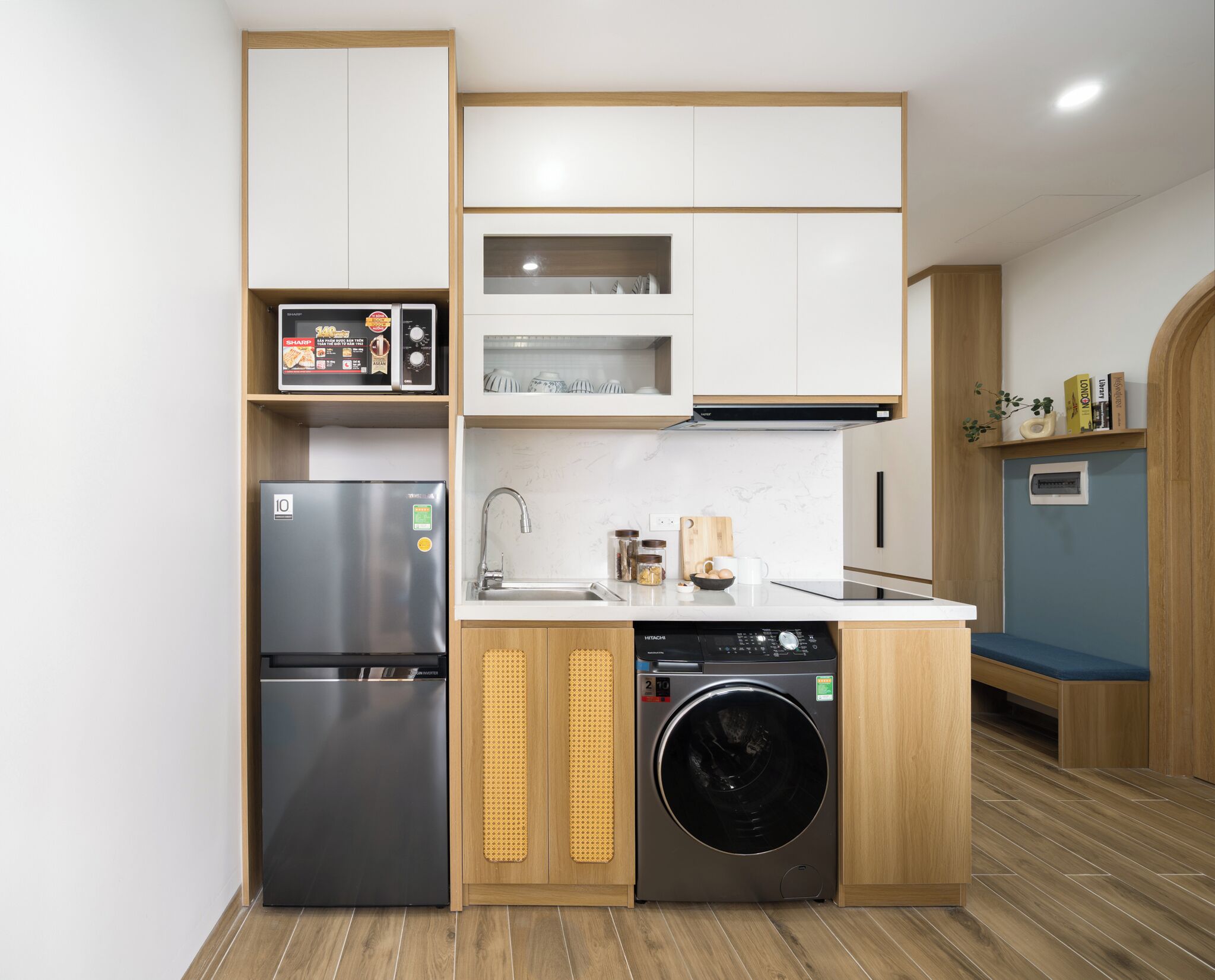 Eine kompakte Küche mit Kühlschrank, Geschirrspüler und Waschmaschine.