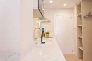 Suite estudio Deluxe, balcón, vistas a la playa | Cocina privada | Frigorífico pequeño, microondas, placa de cocina y utensilios de cocina