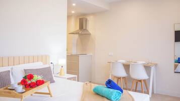 Une chambre d’hôtel avec un lit, un bureau et une kitchenette.