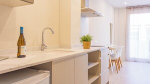 Eine moderne Küche mit einer Weinflasche, einem Spülbecken und einem Blumentopf.