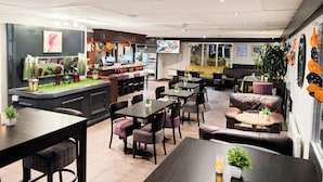 A restaurant with a bar area, seating arrangements, and a television screen. - The Beacon Hotel, Cardiff, Part of the AG Collection (Cardiff)