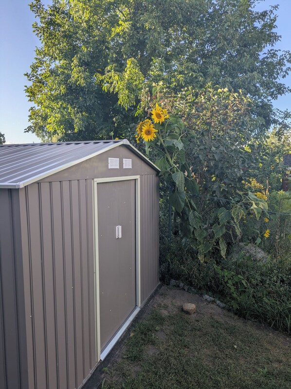 A small, single-story shed with a metal roof and a door with a handle. - 250 m from the Woblitzsee - quiet apartment with WLAN, terrace, bicycle garage (Wesenberg)