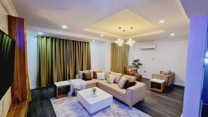 A modern living room with a sectional sofa, a coffee table, and a TV.