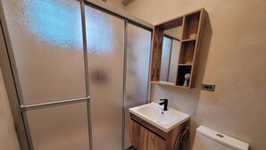 A bathroom with a shower, sink, and toilet.