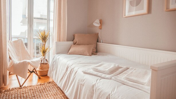 A bedroom with a bed, a chair, a lamp, and a framed picture on the wall. - Chic & Classy Lisboa by GT House (Lisbon)